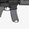 Close-up of a black rifle with a magazine on a white background