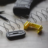 Yellow and black tool on a wooden surface with wires and a pen.