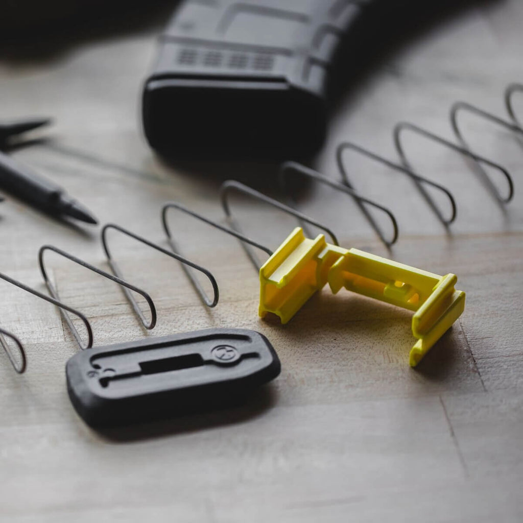 Yellow and black tool on a wooden surface with wires and a pen.