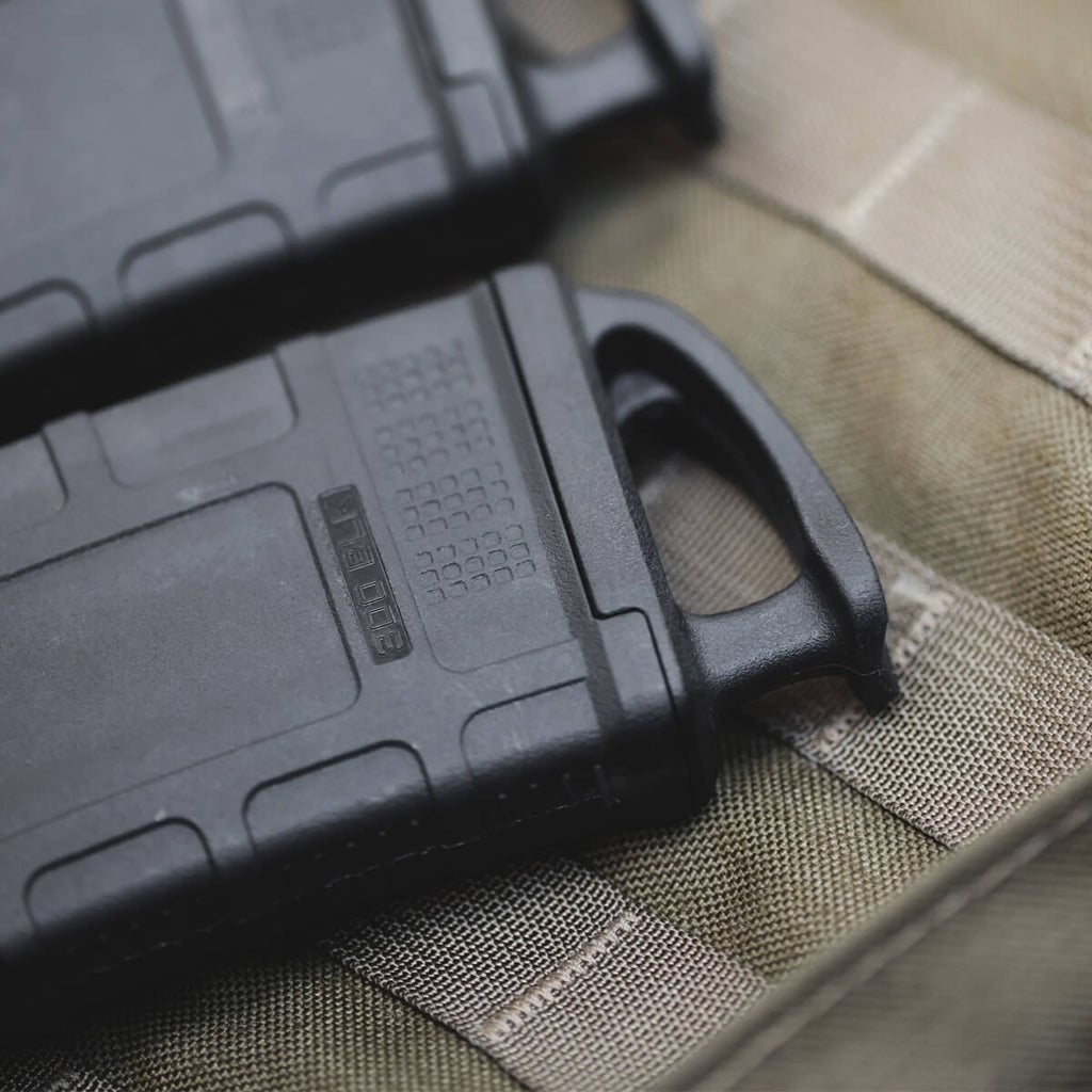 Black tactical magazine on a green military-style pouch