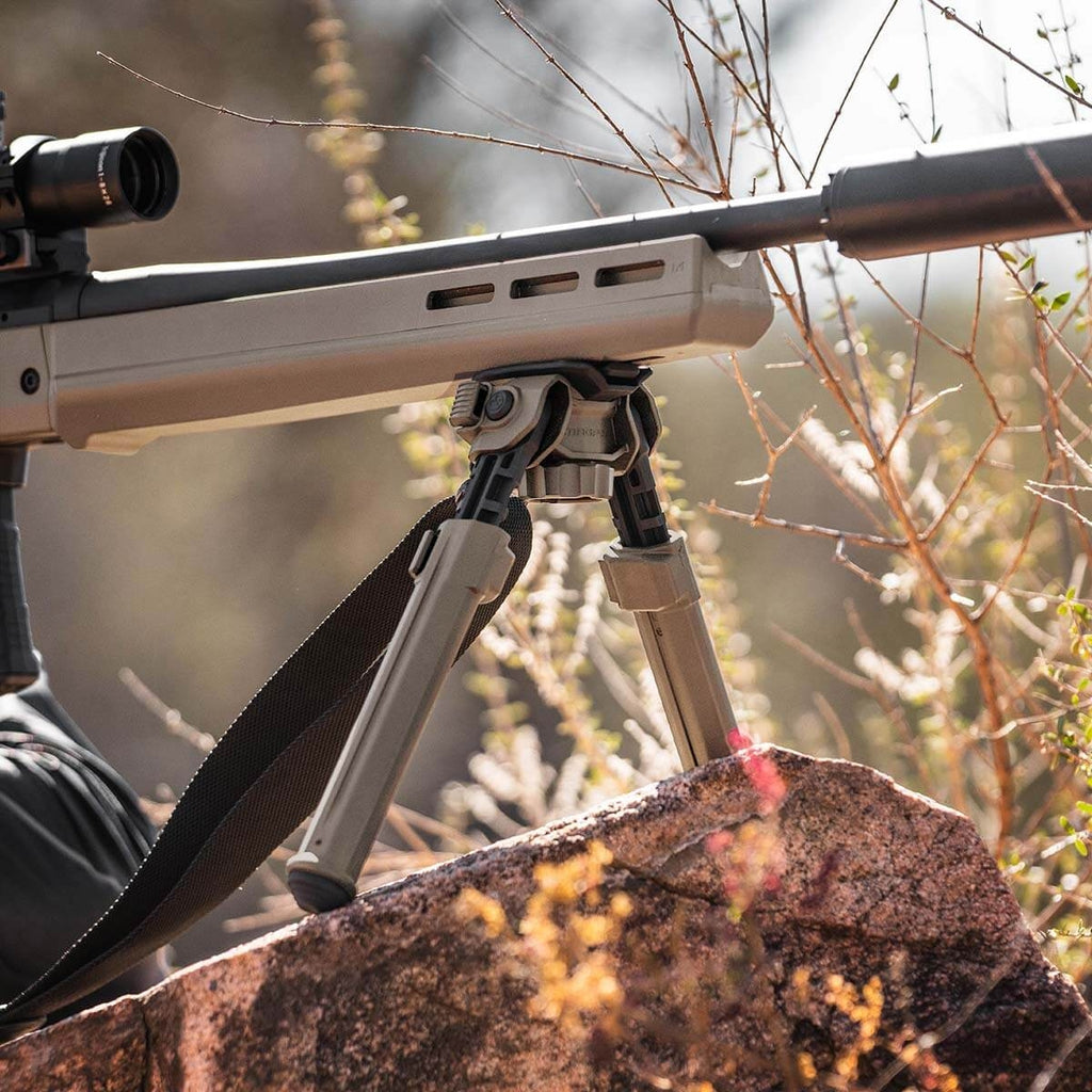 Rifle with a scope on a bipod against a natural background