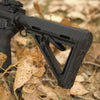 Black rifle stock on a natural background with leaves and rocks