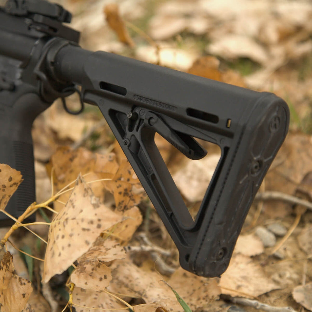 Black rifle stock on a natural background with leaves and rocks