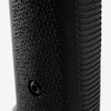 Close-up of a black textured object with grooves on a light gray background
