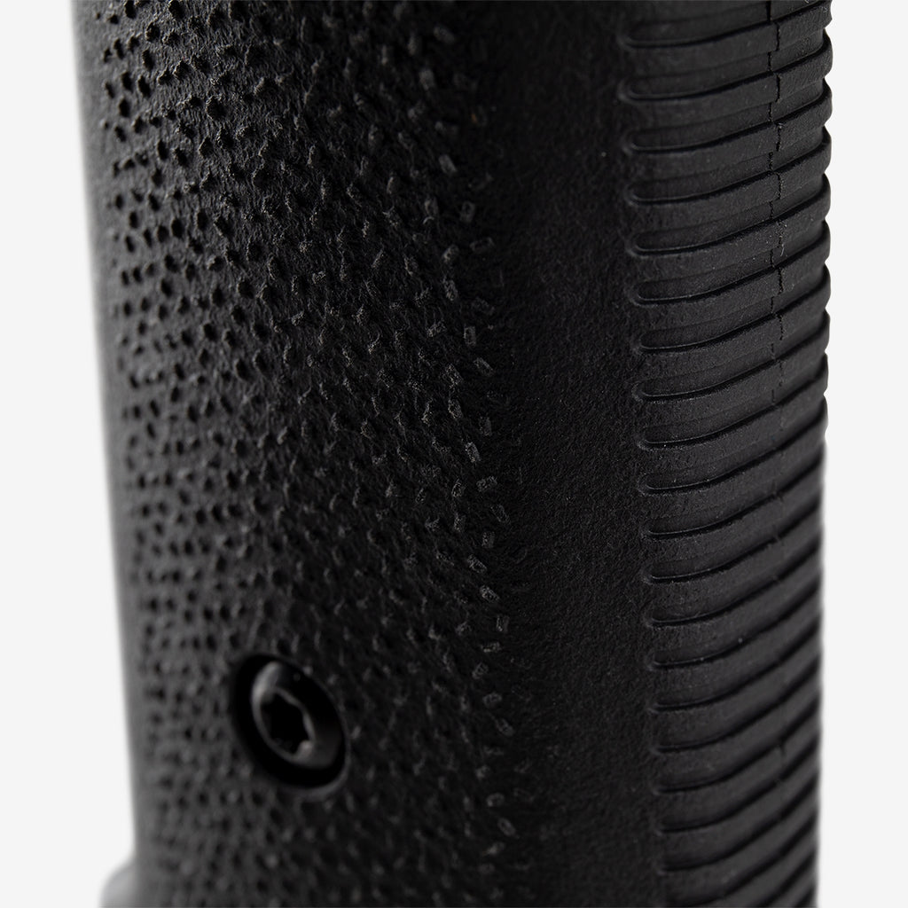 Close-up of a black textured object with grooves on a light gray background
