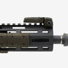 Close-up of a black rifle barrel with green accents on a white background