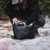 Person in outdoor setting with a black bag