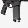 Close-up of a black rifle with 'Magpul' branding on a white background