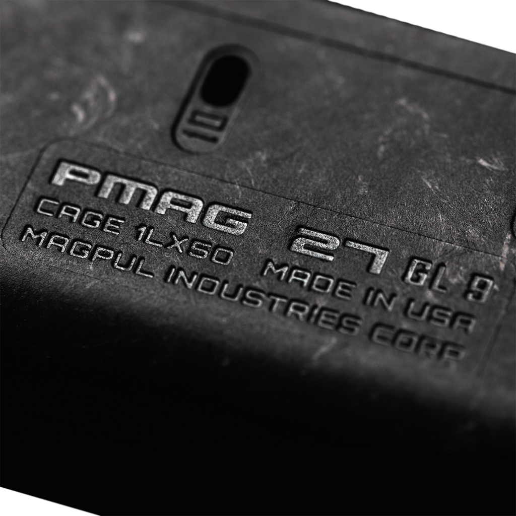 Close-up of a black PMAG magazine with branding text.