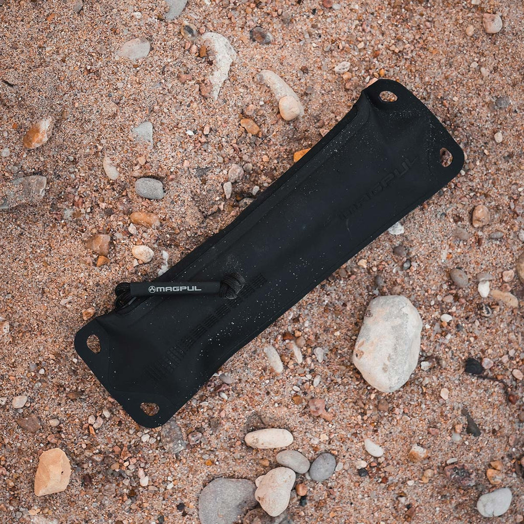 Black sheath with Magpul branding on a sandy surface