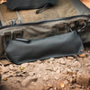 Black waterproof bag with 'Pacsafe' branding on a rocky ground